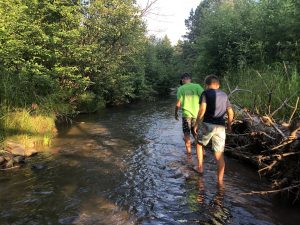 young people walking in a stream